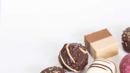 Chocolate pralines truffles with empty space for text.
Selection round truffles confection design for Birthday gift. Luxury candies in white background. Assortment of colorful milk chocolate with nuts