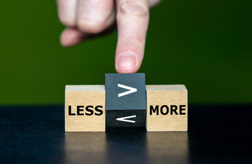 Less is more concept. Hand turns dice and changes the 'smaller symbol' to the 'greater symbol'...