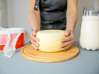 hands hold caciotta cheese,close up, cheese maker,homemade cheese maker,Italian semi-soft cheese