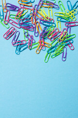 Obraz na płótnie Canvas Set of multicolored paper clips on blue background.