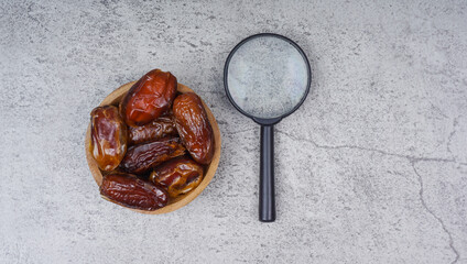 Top view dried date fruit with magnifying glass.