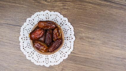 Dried dates fruit or kurma in wooden bowl.