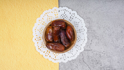 Bowl of dried dates on cement texture background with space for text. From top view