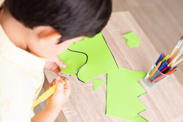 Boy cutting with an adapted scissor lines and shapes