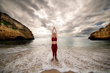 Fototapeta na wymiar Woman standing in the sea practicing yoga and meditation.