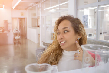 Portrait of an Asian woman with long hair looking to the side, smiling happily. then there is a beautiful light shining from behind. some blur face.