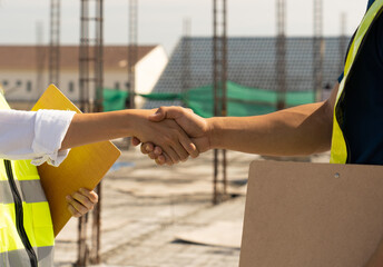 Handshake of civil technician engineer and professional architect while inspect and discuss...