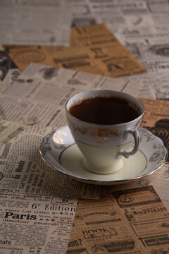 photo of a cup of coffee on a tabletop made of newspaper clippings