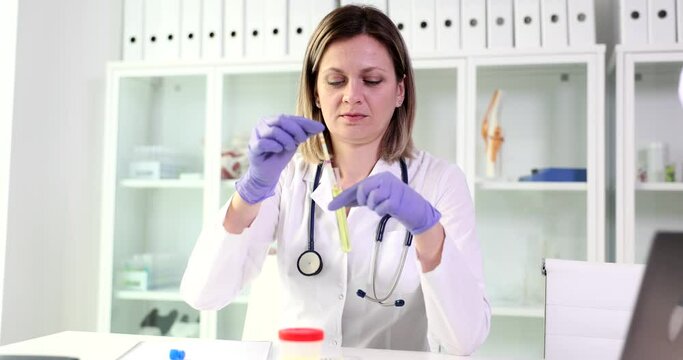 Doctor holds test tube with urine sample for analysis closeup