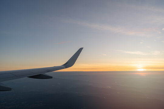 Beautiful sunset, sky on the top view, airplane flying view from inside window aircraft of Traveling.. Sunlight and flare background concept.