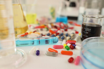 Colored capsules and test tubes on the table in laboratory