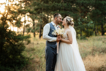 the groom and the bride are walking in the forest
