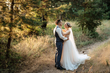 the groom and the bride are walking in the forest