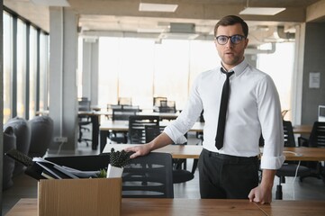 Sad Fired. Let Go Office Worker Packs His Belongings into Cardboard Box and Leaves Office....