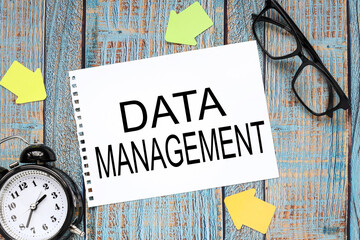 DATA MANAGEMENT blue wooden background. text on paper