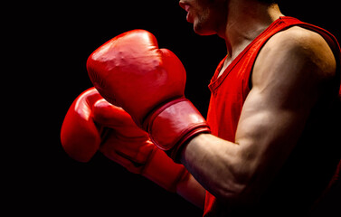 close-up boxer in red gloves on black background
