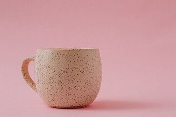 Empty ceramic cup on pink background, copy space