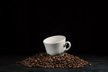 Naklejka premium A cup of espresso coffee on coffee beans. Cup of natural coffee on a black background