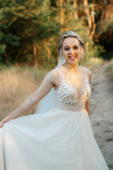 Fototapeta na wymiar bride blonde girl with a bouquet in the forest