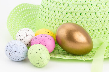 Gold nest egg stands out from pastel colored eggs reflecting business concept of well managed, differentiated investments