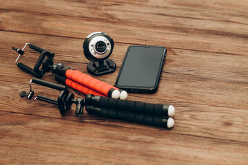 Two manual tripod monopods for a phone or a small camera on a wooden table.