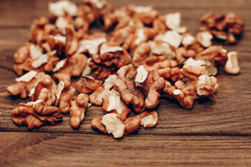 Dried walnut grains scattered on a wooden table.