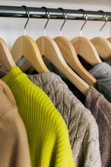 Obraz premium The basic wardrobe of a fashion stylist. Neutral colors: white, brown, beige, grey. Bright colors: yellow. White wardrobe, wooden hangers and towels