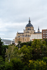 Fototapeta na wymiar Almudena Cathedral and Vistillas Park in Madrid. Cloudy day. Vertical photography