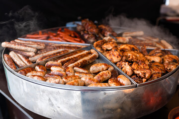 Tasty hot grilled sausages, chicken wings and barbecue in street market ready to eat