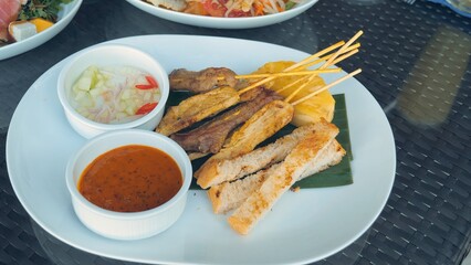 Grilled chicken skewers with bread, onions, and spicy sauce