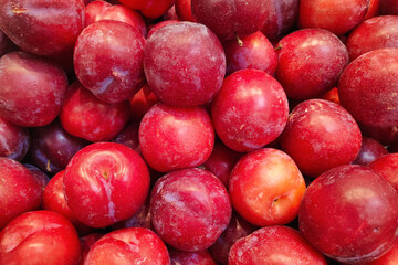 Stack of red plums on a market stall