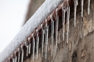 Ice stalactites at the edge of a wall