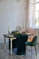 The luxury served table indoors in green colors. Dark wooden table, beautiful evening restaurant with luxury decor