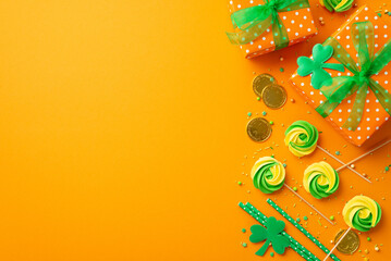 Saint Patrick's Day concept. Top view photo of gift boxes with green ribbon bows meringue lollipops sprinkles gold coins straws and trefoils on isolated orange background with copyspace