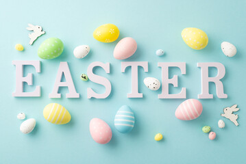 Easter concept. Top view photo of word easter colorful eggs and bunnies on isolated pastel blue background