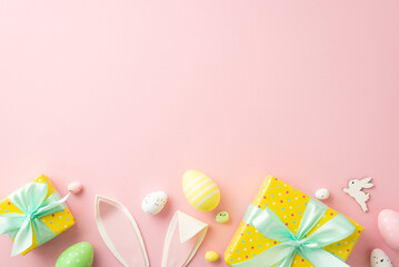 Easter celebration concept. Top view photo of stylish yellow gift boxes with blue ribbon bows colorful easter eggs and bunny ears on isolated pastel pink background with copyspace