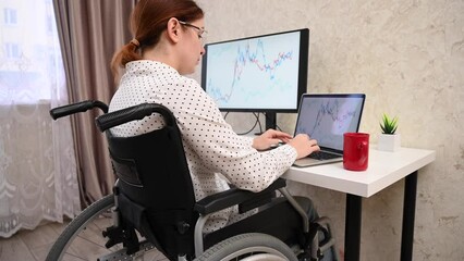 Caucasian woman in a wheelchair typing with a laptop from home. Remote work for people with disabilities.