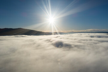 Centered sun - in evening light - aerial drone view right above the dense cloud cover