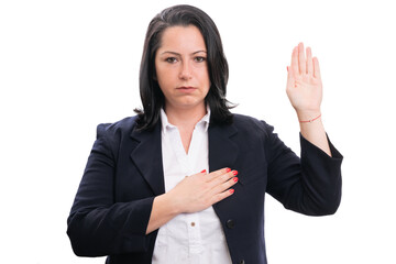 Businesswoman with serious expression making oath gesture