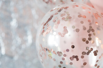 Pastel pink and transparent balloons on silver foil background