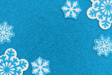 Snowflakes on blue glitter material winter background