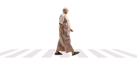 Full length profile shot of a mature arab man in ethinc clothes walking on a pedestrian crossing