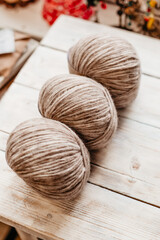 Fototapeta na wymiar Three coils of soft woolen threads on a wooden background side view