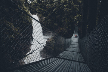 Bridge over large waterfall in beautiful Canadian wilderness after rain in moody misty day