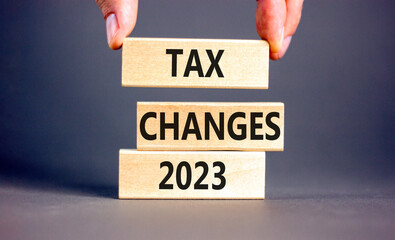 Tax changes 2023 symbol. Concept words Tax changes 2023 on wooden blocks on a beautiful grey table...