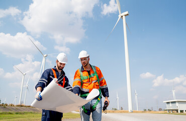 Two engineers or technician discuss about project or work using drawing paper and stand in front of...