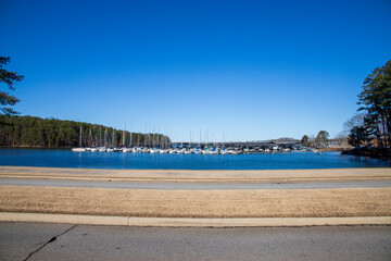 Boats and yachts docked in the marina on Lake Lanier with lush green trees and a gorgeous clear...
