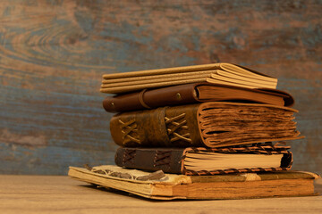 antique books and notebooks bound in leather with faux leather straps stacked on top of each other...