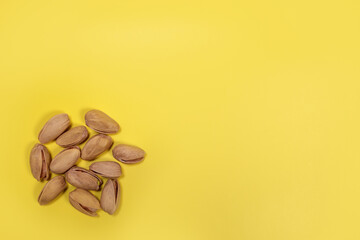 Organic pistachios nuts on a yellow background. copy space for text