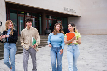 Young university students leaving the library together after studying. Concept: education, studies, future